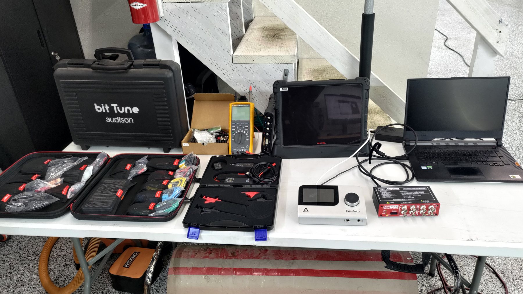 Audio testing equipment, leads and laptop arranged on a workbench
