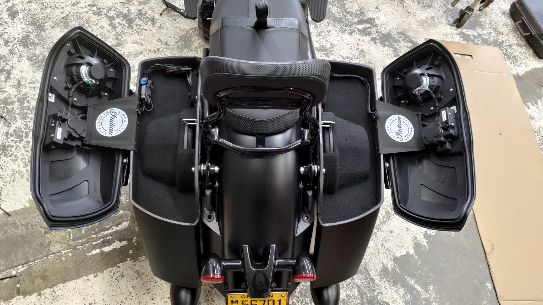 Open motorcycle saddlebags showing installed speakers and wiring