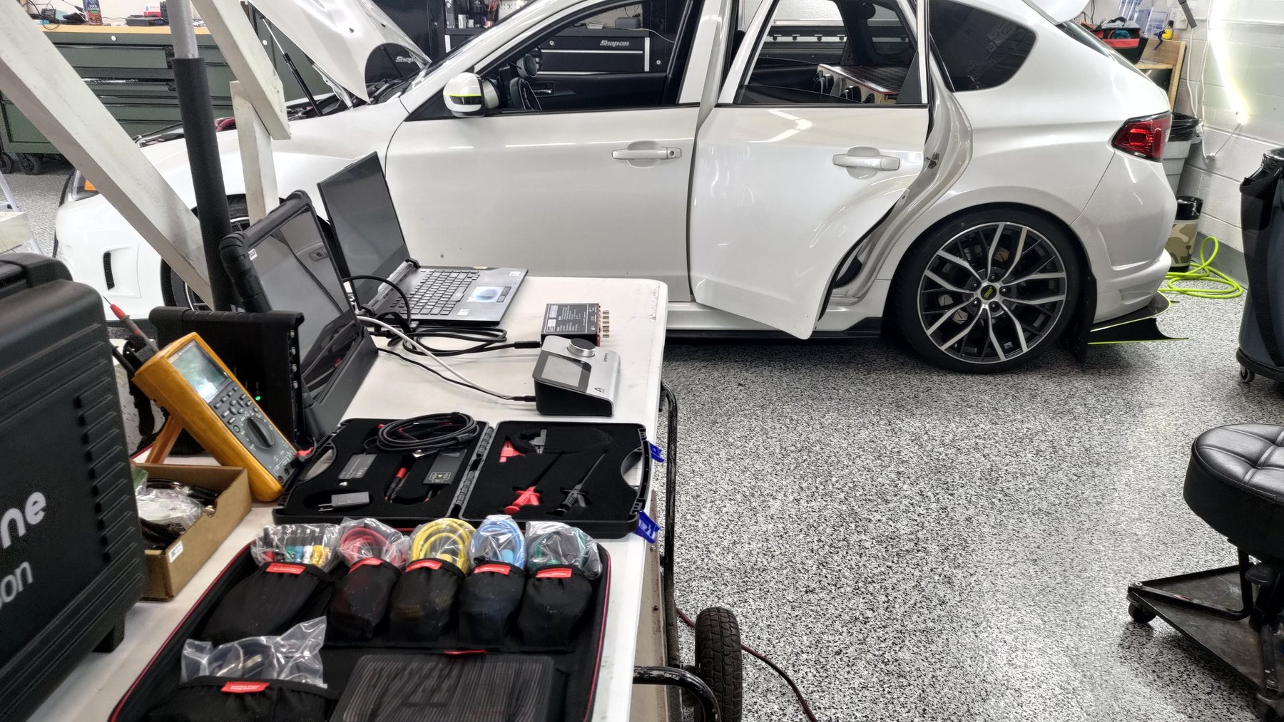 Audio measurement equipment and laptop beside a white car with its door open
